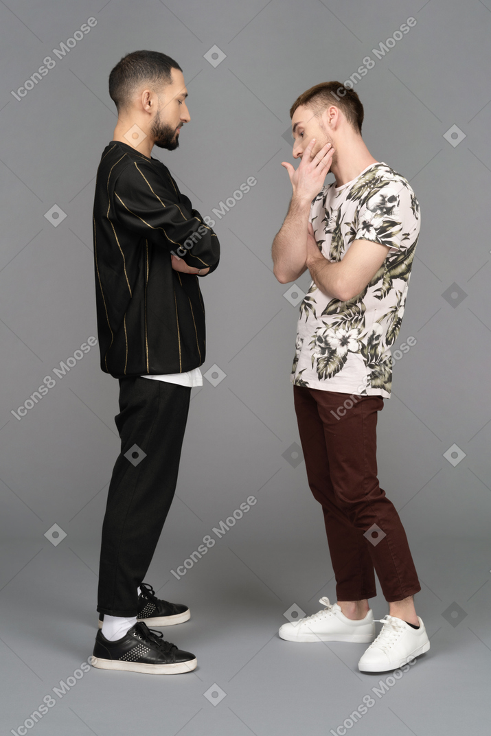 Side view of two young men looking troubled and concerned