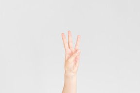 Mão feminina, mostrando três dedos