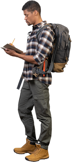 Side view of a tourist with a backpack writing down in his notepad