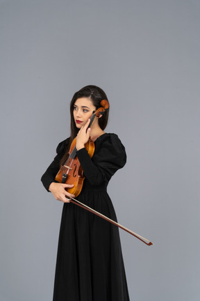 Close-up of a young lady in black dress holding the violin