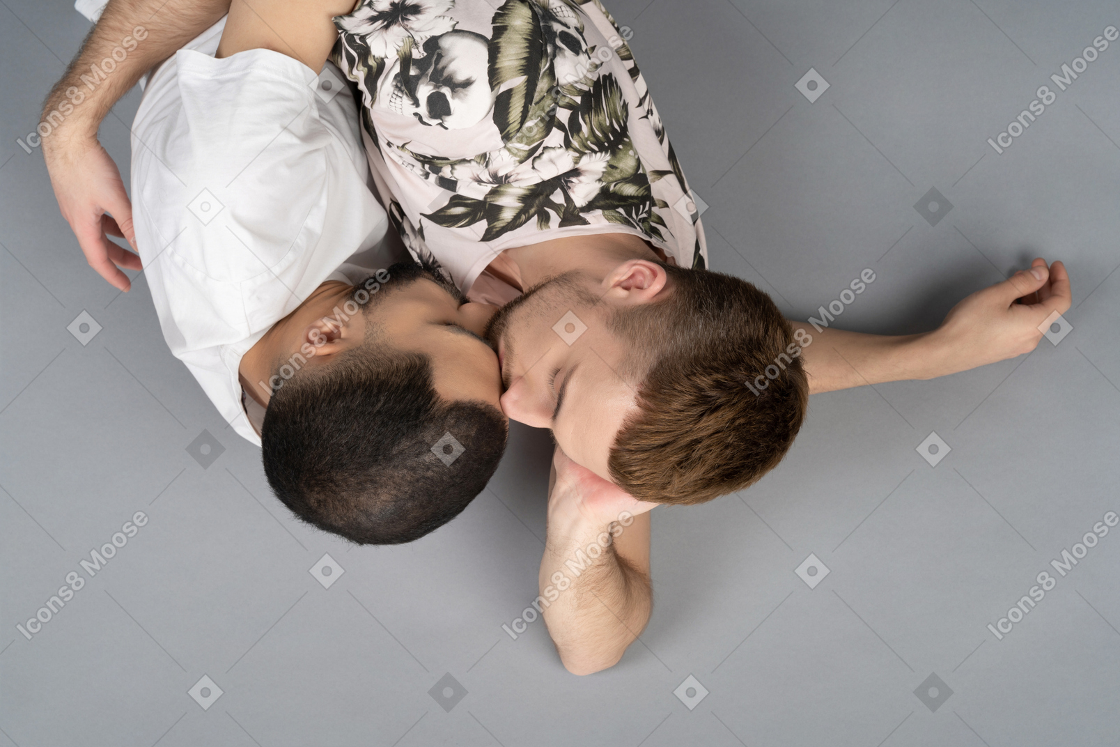 Flat lay of two young caucasian men lying on the floor one kissing another's forehead