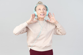 Old lady in listening music in headphones