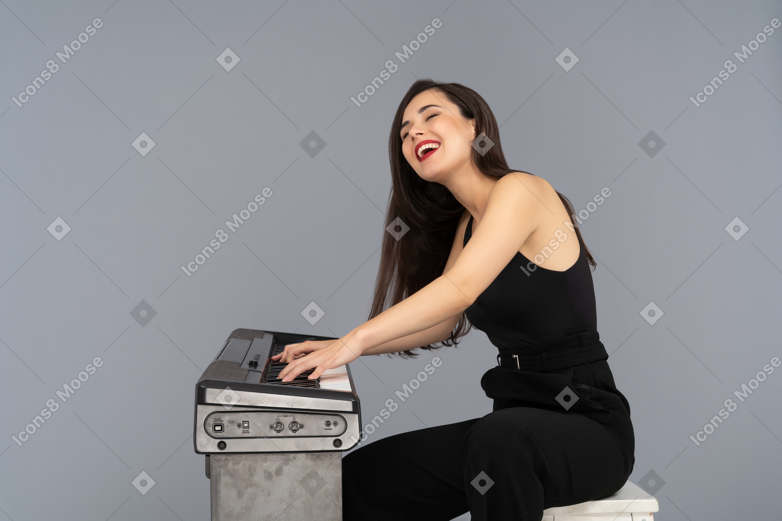 Donna allegra che ride ad alta voce mentre suona un pianoforte
