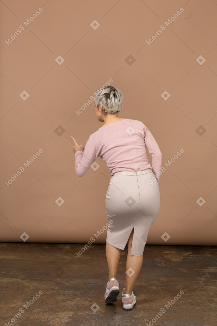 Rear view of a woman in casual clothes showing warnin sign