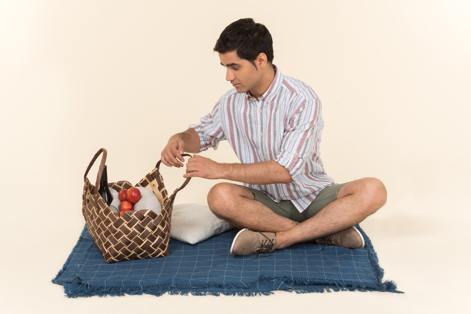 Young caucasian guy looking into picnic basket