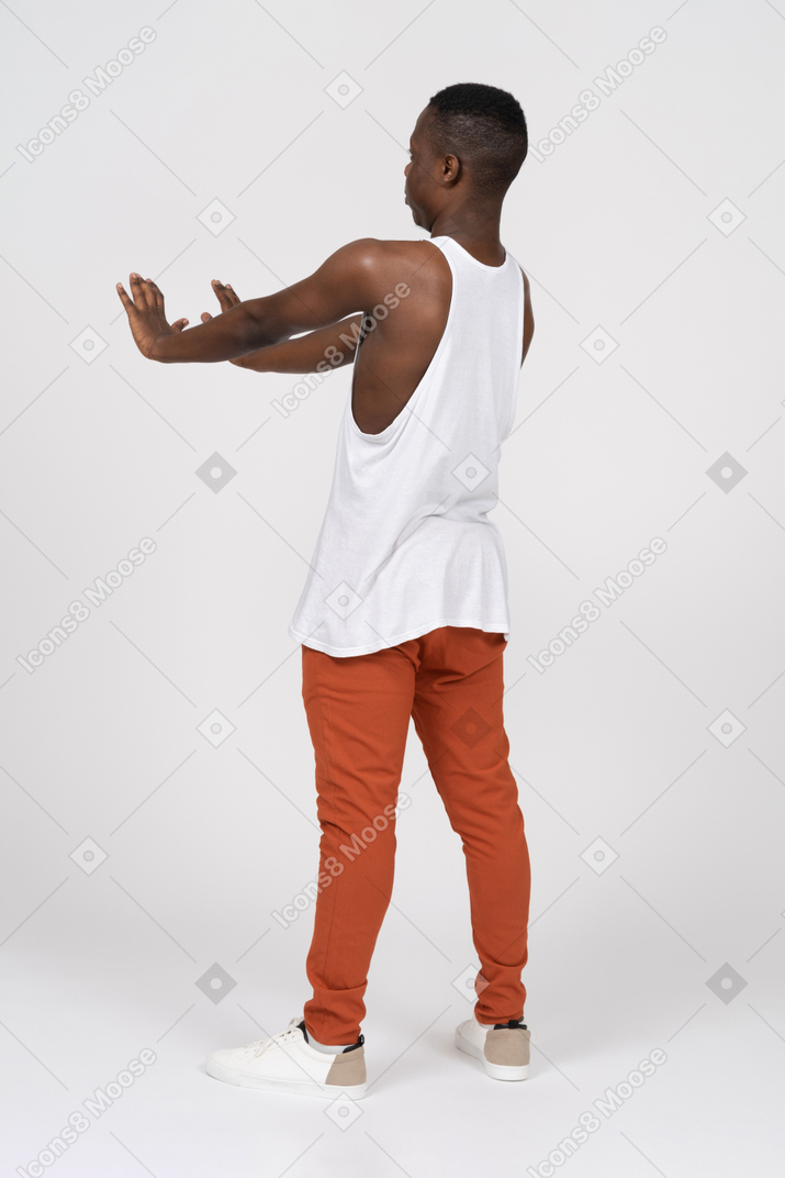 Vista posteriore dell'uomo nero muscoloso che estende le braccia in avanti