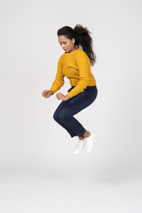 Side view of a girl in casual clothes jumping