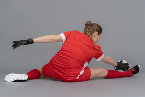 Uma jogador de futebol feminino que se estende antes da partida