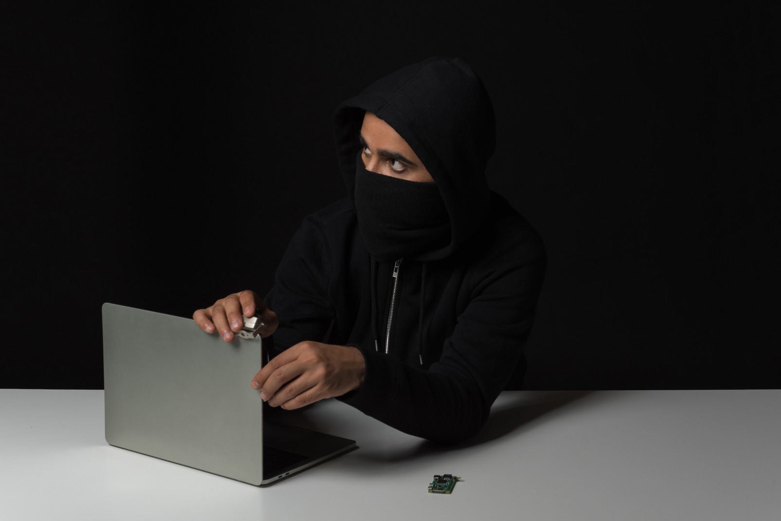 Hacker guy removing laptop in the dark