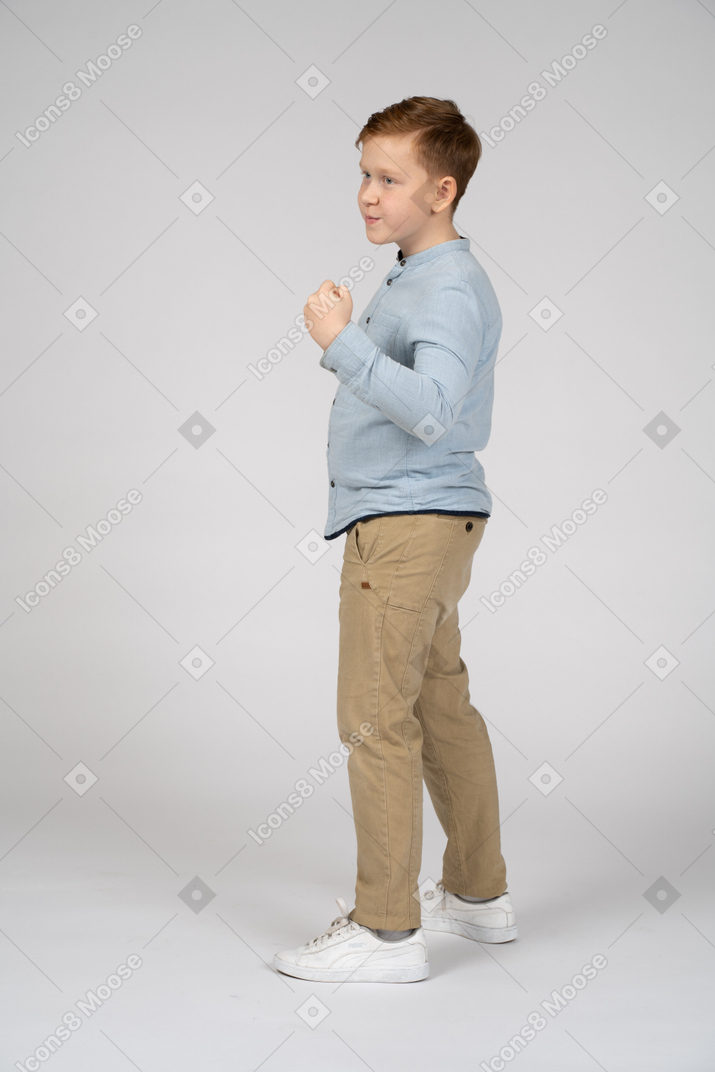Side view of a boy showing fist