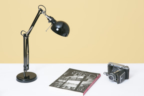 Schreibtischlampe, vintage-kamera und buch