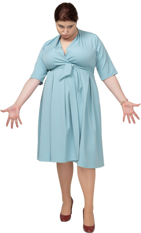 青いドレスを身振りで示す女性の正面図