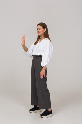 Three-quarter view of a young lady in office clothing showing ok gesture