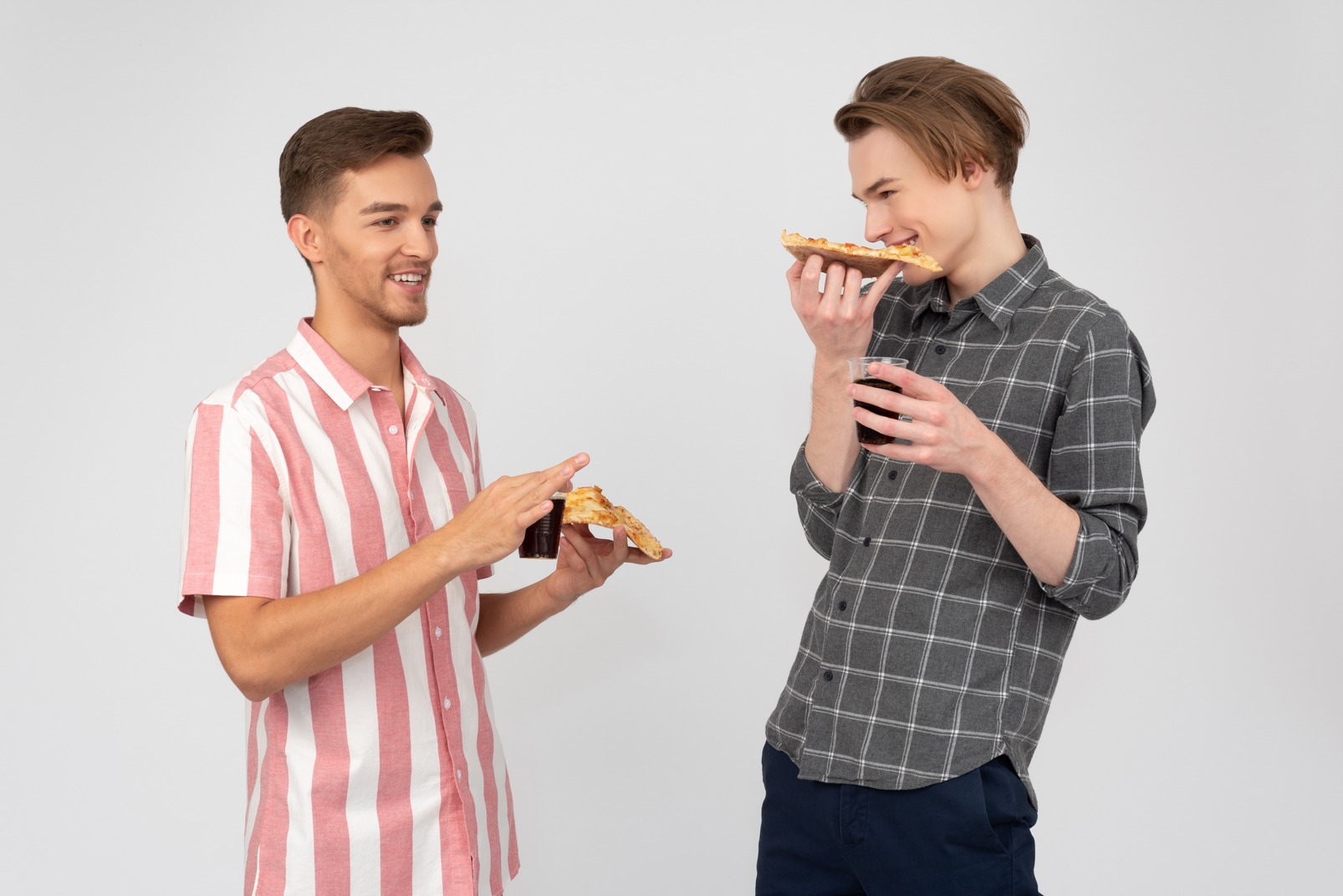 Two guys talking and having pizza and drinks
