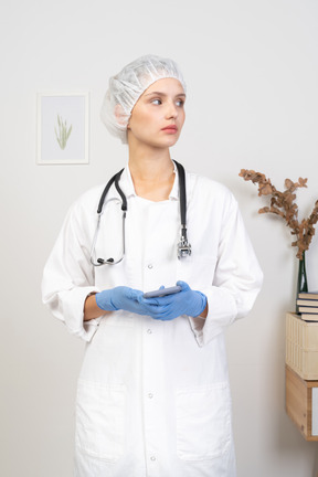 Vista frontal de una joven doctora con estetoscopio sosteniendo su teléfono