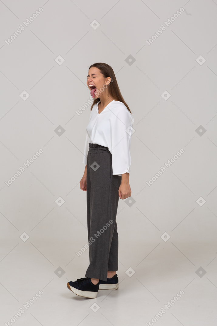 Three-quarter view of a screaming young lady in office clothing showing tongue