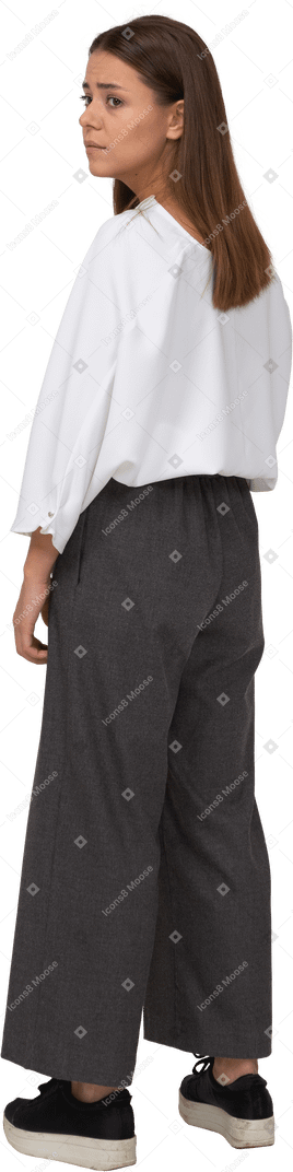 Three-quarter back view of a sad young lady in office clothing looking aside