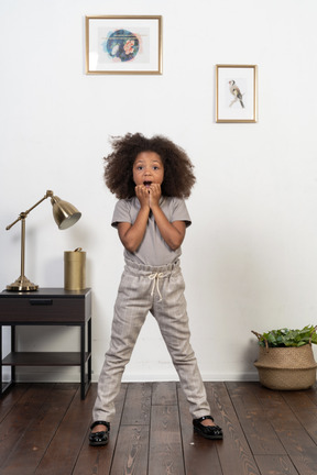 Good looking girl kid posing on the apartment background