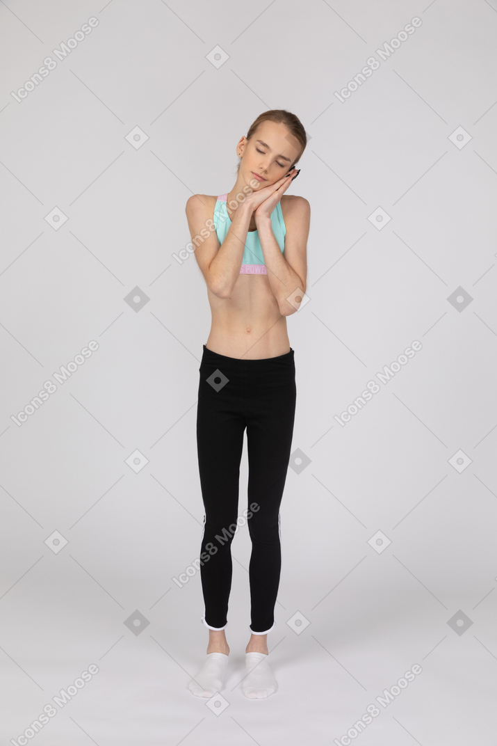 Una adolescente con ropa deportiva fingiendo dormir