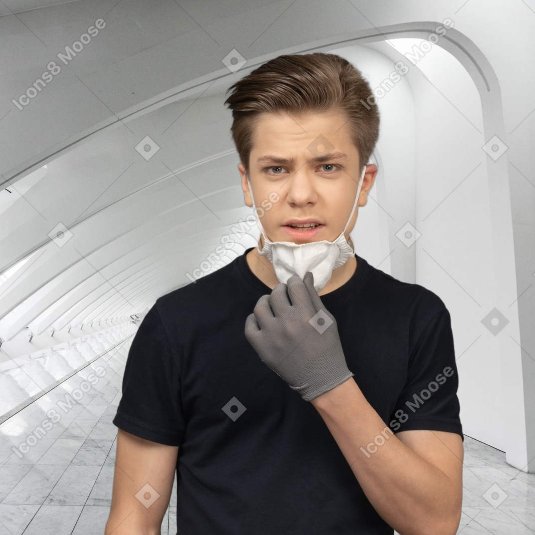 Confused young man taking off face mask