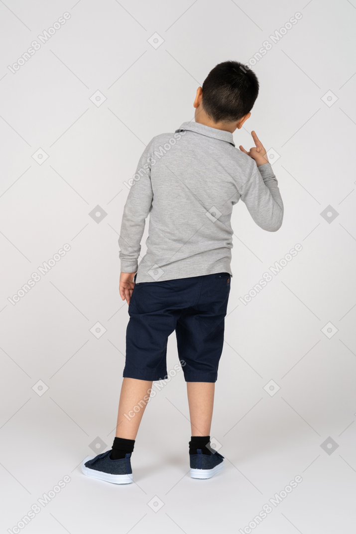 Rear view of a boy showing sign of the horns