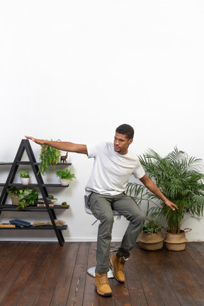 Good looking young man posing on the background of the apartment