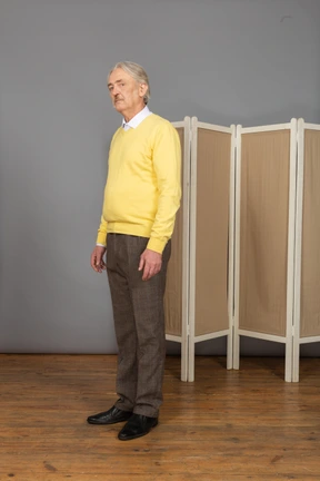 Three-quarter view of a serious old man looking at camera