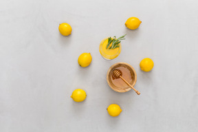 Bowl of honey, lemons and lemon juice with rosemary leaves