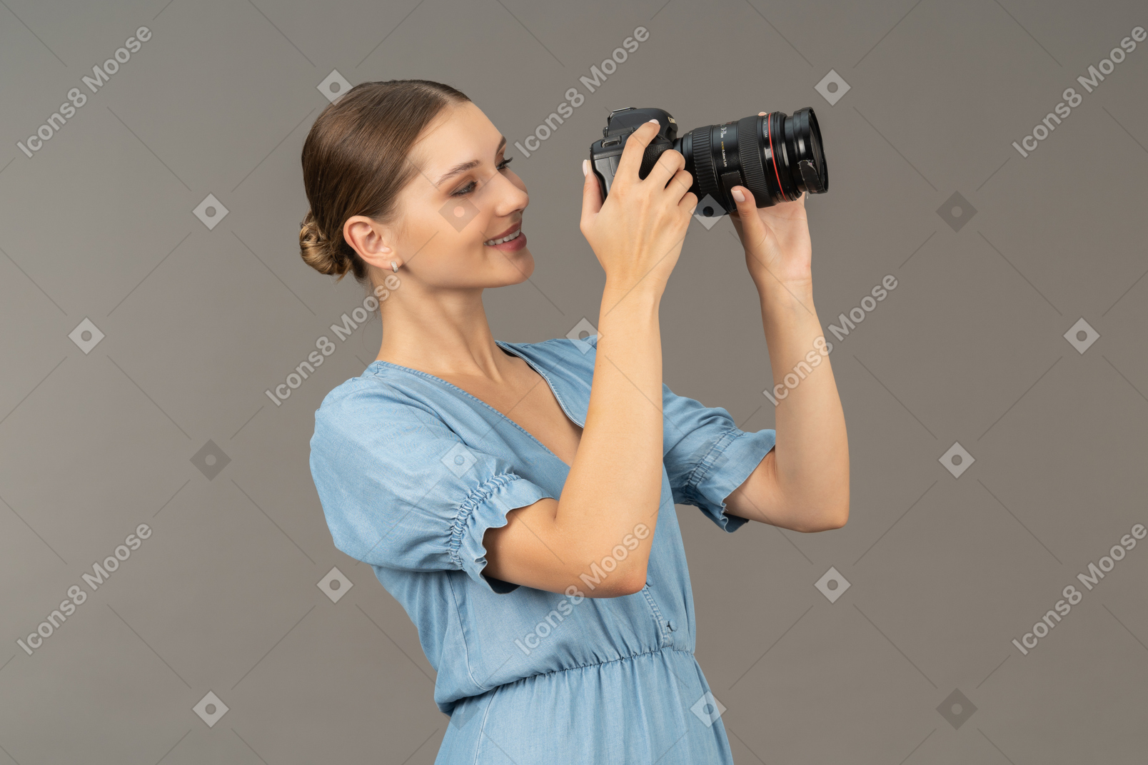 Vista de três quartos de uma jovem sorridente com vestido azul tirando uma foto