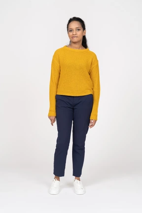 Front view of a girl in casual clothes biting lips and looking at camera