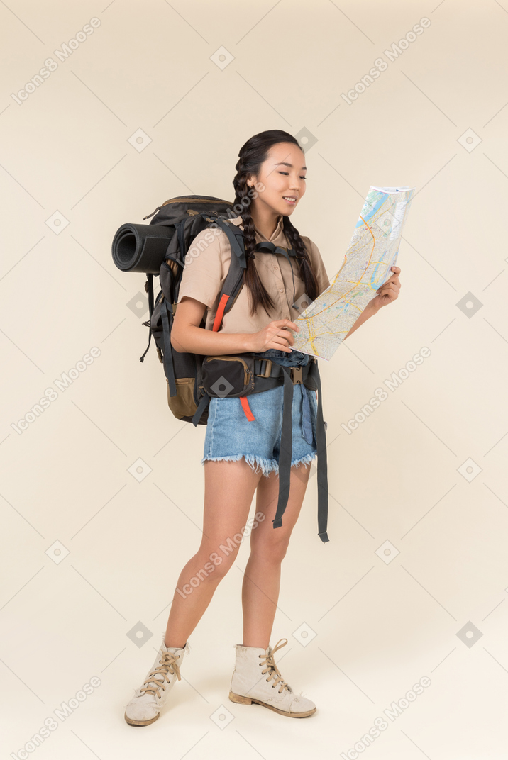 Joven excursionista asiática leyendo el mapa