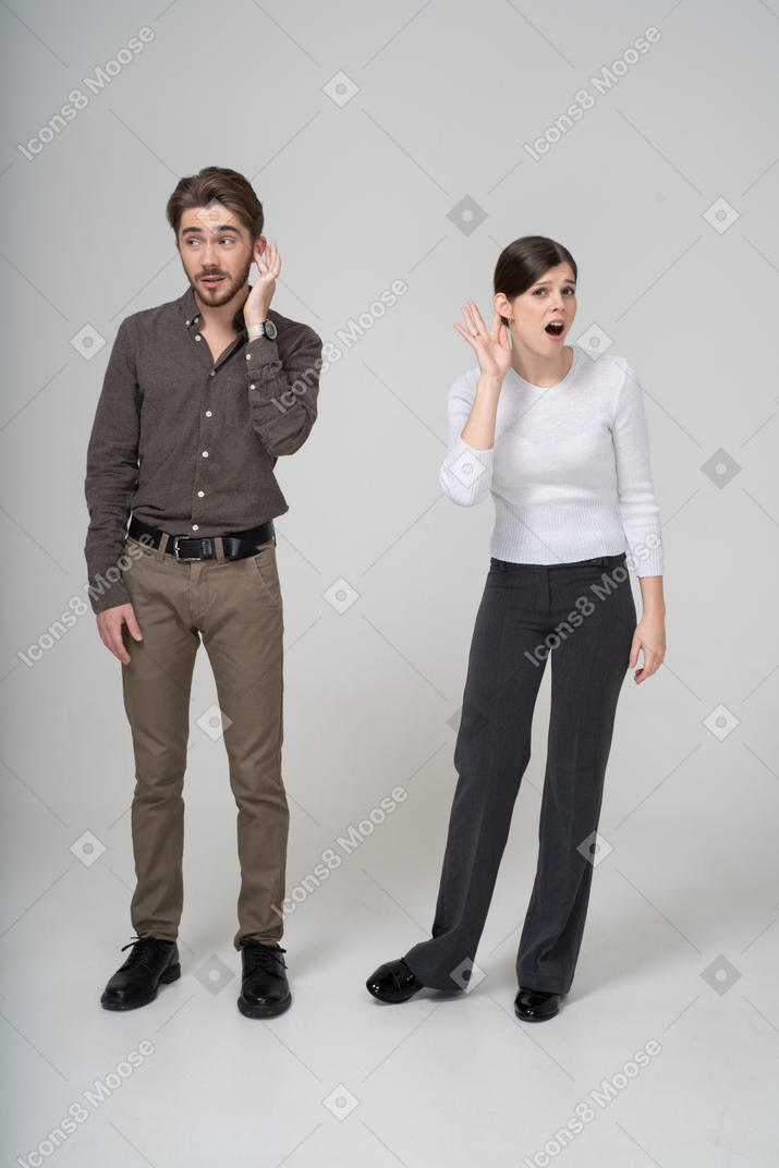 Front view of a young couple in office clothing listening to the rumors