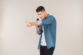Laughing young stand-up presenter showing thumb up