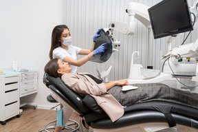 Longitud total de una mujer dentista y su paciente mirando rayos x