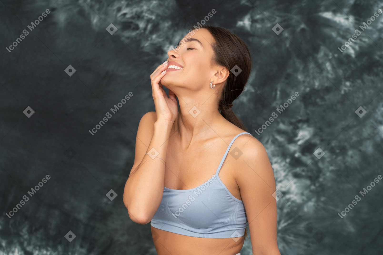 Close-up a smiling woman in sports bra touching her face and smiling