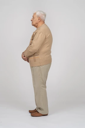 Old man in casual clothes standing in profile