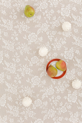 Zéfiro e peras em uma toalha de mesa com design de flores
