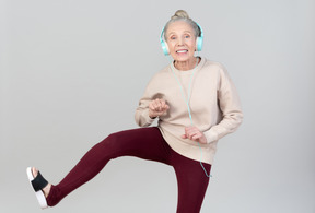 Joyful young lady in headphones dancing to music