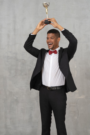 Man holding up award in celebration of his win