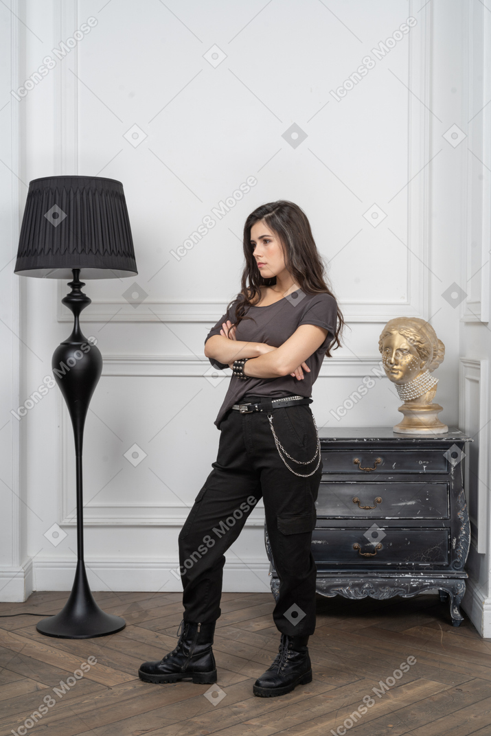 Three-quarter view of a displeased female rocker crossing her hands