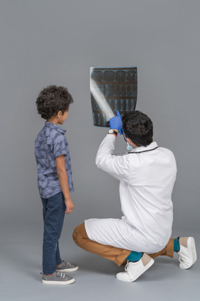 Menino olhando um raio-x com médico