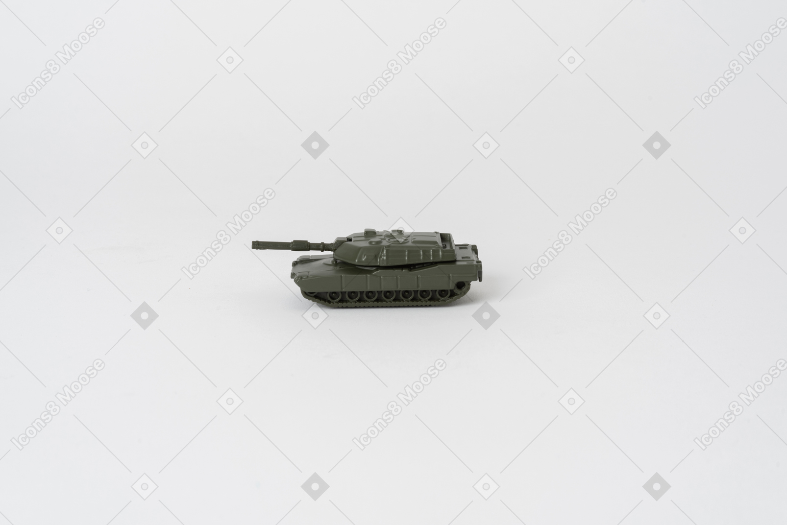 평범한 흰색 배경에 서있는 장난감 탱크의 측면 샷