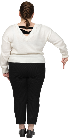 Plus size woman in casual clothes pointing down with a finger