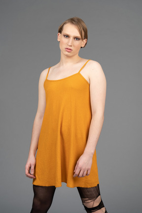 Vista frontal de uma jovem genderqueer de vestido laranja