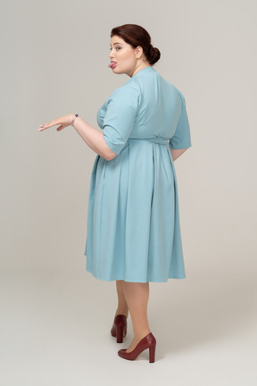 Rear view of a woman in blue dress making faces