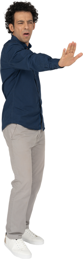 Vista frontal de um homem com roupas casuais mostrando um gesto de pare