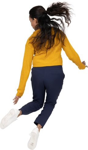 Rear view of a girl in casual clothes jumping
