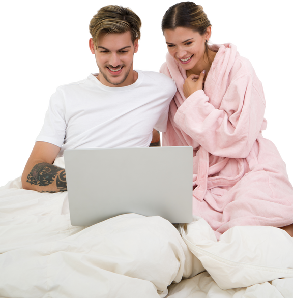 ベッドでノートパソコンで座っている若い幸せなカップル のフォト