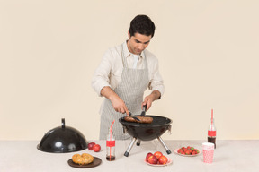 Hombre caucásico joven cocinando barbacoa