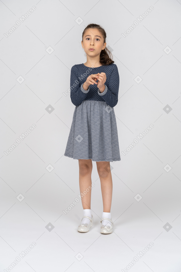 Vista frontal de uma garota brincando com os dedos enquanto diz algo